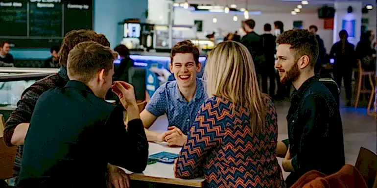 Cafe Bar - group of people smiling around a table in a cafe